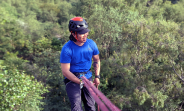 Morning Brief - we'll meet at Basecamp at 08:30 for weather brief and plan the day as a group. Consolidating Group Rigging Skills -varied practice and a look at problem solving and prevention on outdoor crags. Group Abseils - rigging and running group abseils and the common pitfalls to avoid with regards problem solving. Return to Basecamp - return to Basecamp for around 16:00, hand in kit, grab a well-earned brew and review the day. What Next? - your instructor will discuss a personal Action plan and we'll email you some post course resources to help you on your Rock Climbing Instructor journey. Rock Climbing Instructor wearing a climbing helmet and blue t shirt abseiling on a climbing rope from a single pitch crag with a forest below.